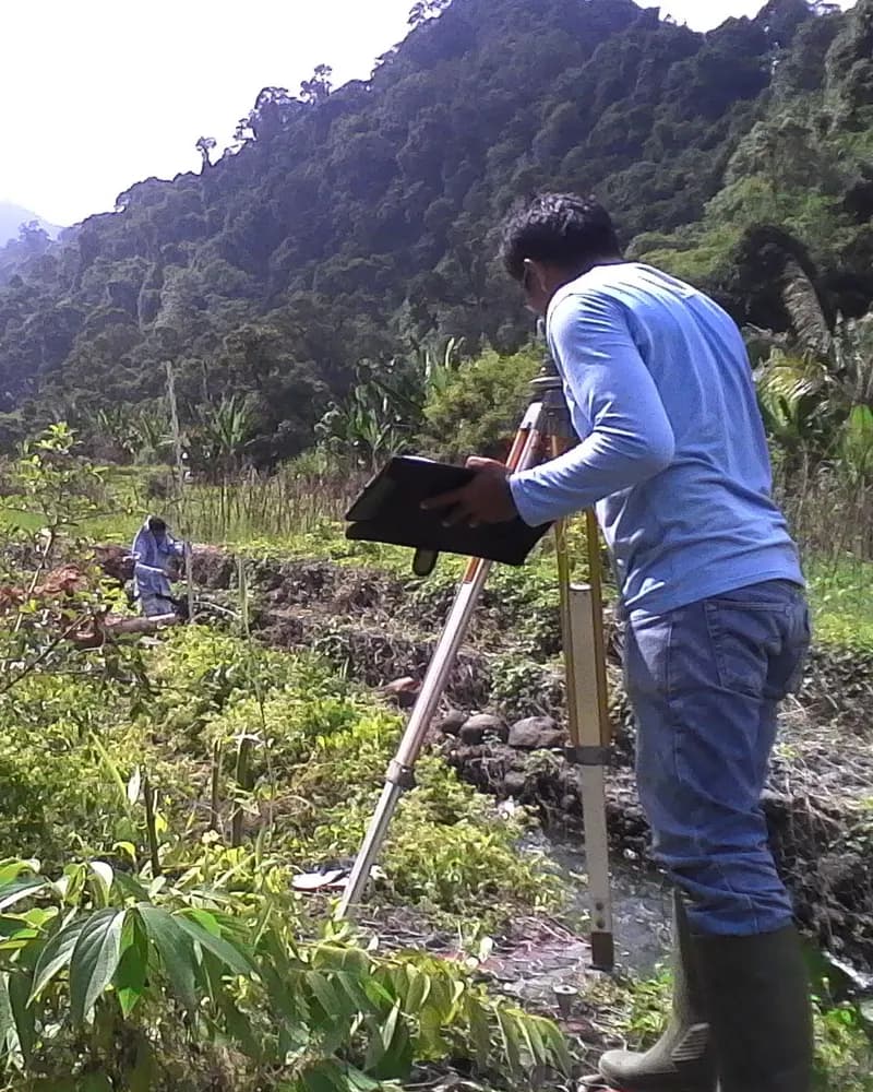 Petugas melakukan survey pengukuran lahan dengan alat ukur